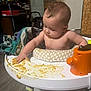 Paxton is registered to the contest to win money with this photo: baby, highchair, messy, food, indoor, child, curious, toddler, face, skin, table, toy, orange, hand, floor, blanket, wood, door, furniture, room