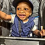 toddler, child, smiling, cap, navy_blue, vest, stroller, harness, happy, reaching, face, eyes, teeth, clothing, person, baby, seat, infant, cute, joyful