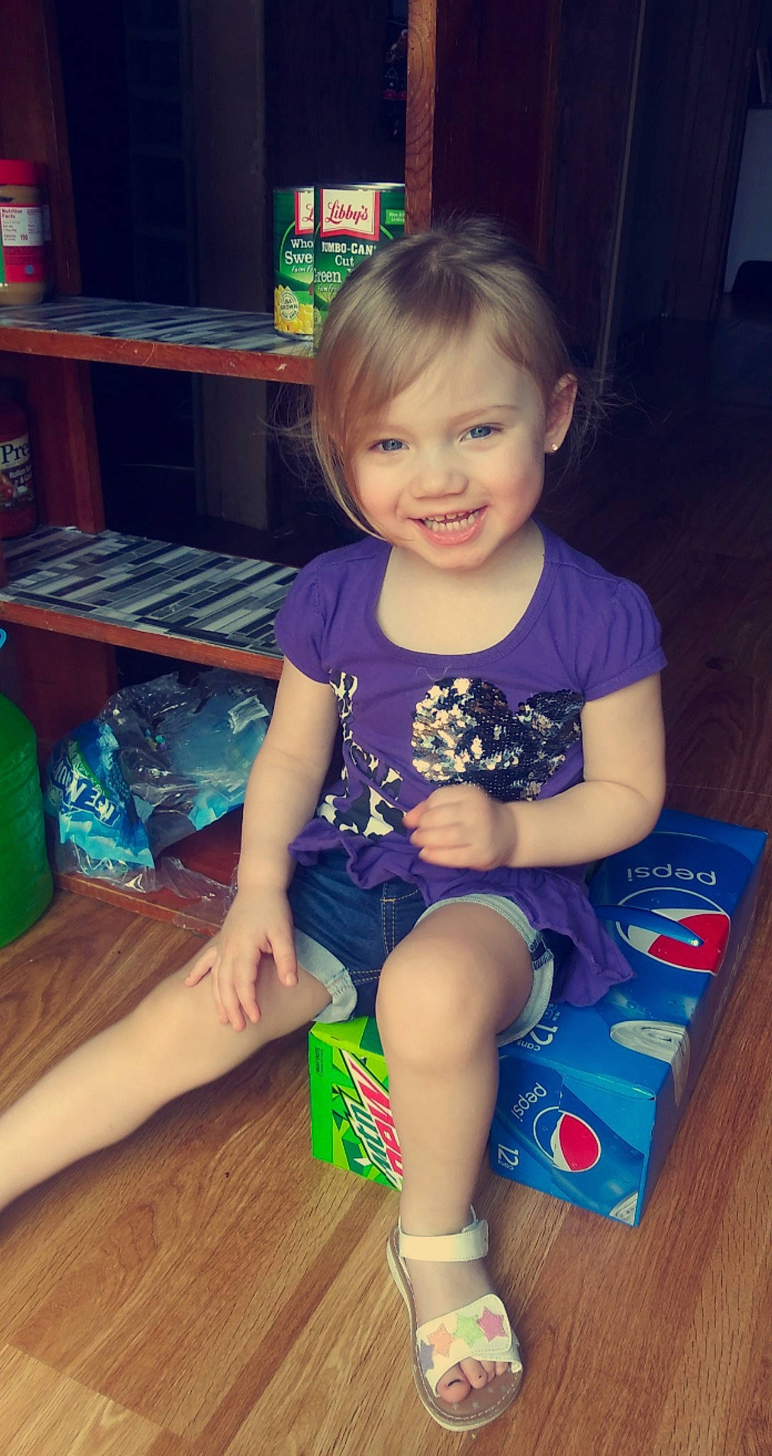 Emmalee joined the competition — help win amazing prizes! baby_toddler_clothing, child, finger, flooring, fun, hair, hairstyle, happy, head, human_leg, iris, joy, lap, person, shelf, skin, smile, standing, t_shirt, thigh