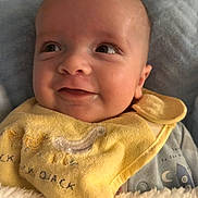 Noah joined the competition — help win amazing prizes! baby, smiling, face, yellow_bib, blanket, infant, clothing, happy, portrait, cute, child, cozy, soft_texture, indoor, closeup, expression, head, skin, sleepwear, newborn