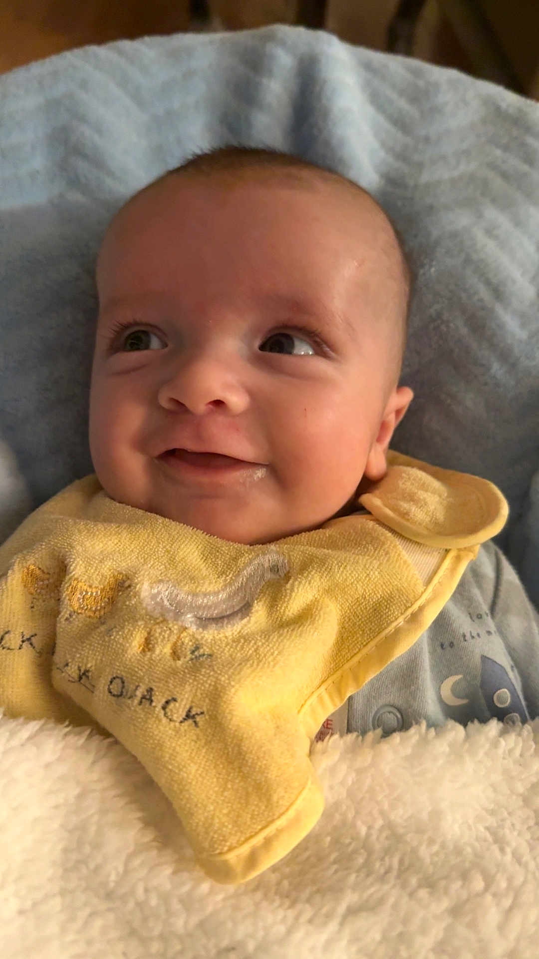 Noah joined the competition — help win amazing prizes! baby, smiling, face, yellow_bib, blanket, infant, clothing, happy, portrait, cute, child, cozy, soft_texture, indoor, closeup, expression, head, skin, sleepwear, newborn