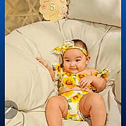 Nya Salyn Cook is registered to the contest to win money with this photo: baby, child, cozy, cushion, happy, headband, indoors, infant, legs, milestone_sign, number_5, outfit, pillow, playback_bar, portrait, sandals, seat, smile, sunflower_print, video_screenshot