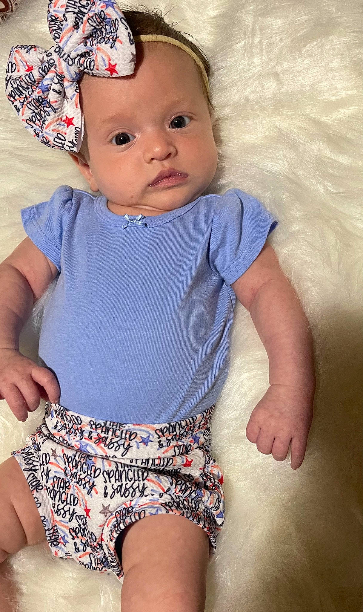 Amelia is registered to the contest to win money with this photo: baby_toddler_clothing, cheek, chin, eye, face, facial_expression, finger, hand, head, human_body, iris, neck, organ, person, photograph, pink, skin, sleeve, textile, toddler