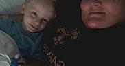 Waylon is registered to the contest to win money with this photo: child, adult, smile, indoor, bed, blanket, toy, face, person, closeup, family, cozy, dim_light, casual, portrait, tired, snuggle, relaxed, hair, clothing