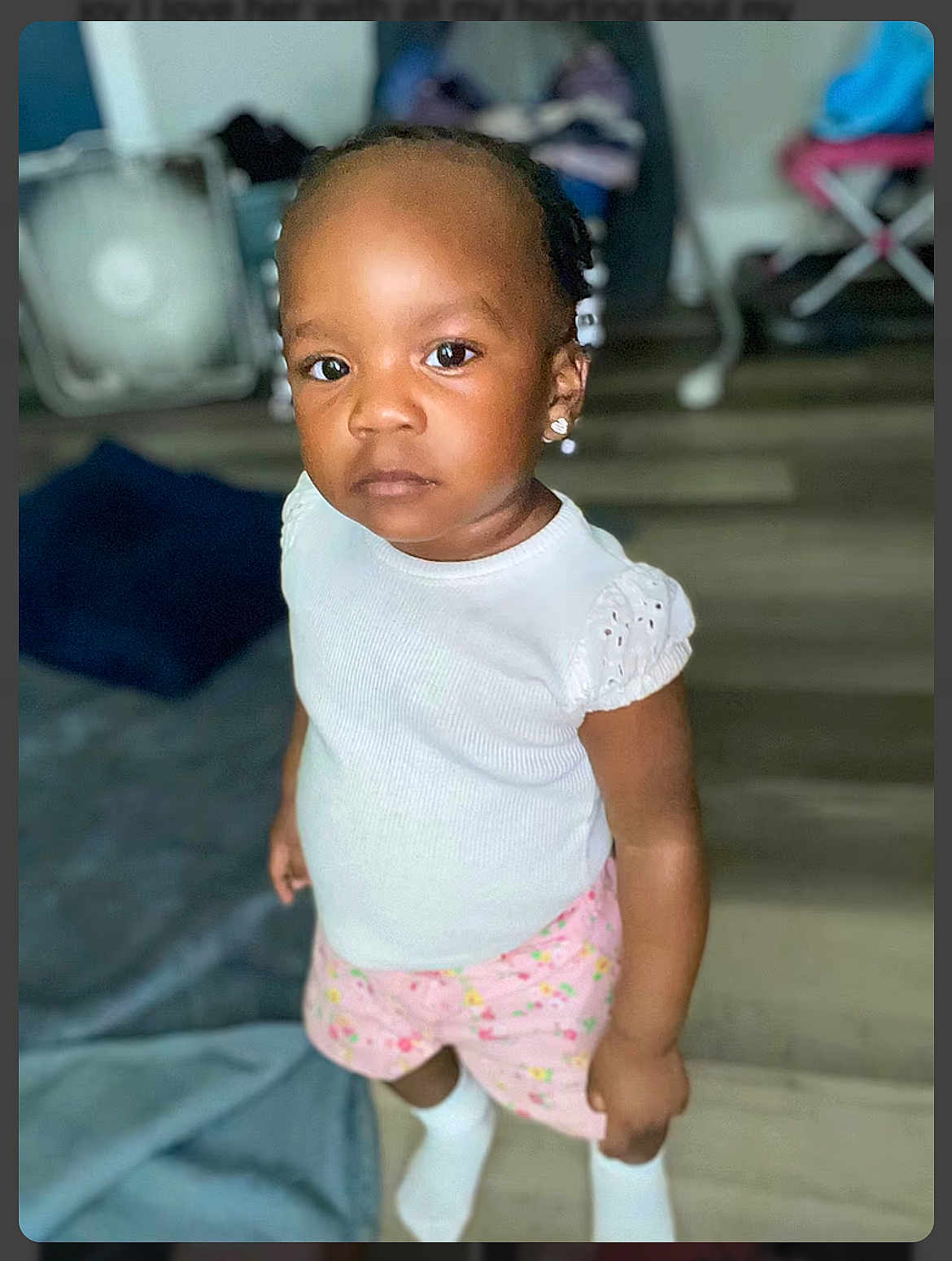 Damira joined the competition — help win amazing prizes! carpet, child, earrings, ears, expression, face, floor, furniture, hair, home, indoor, looking_at_camera, person, pink_shorts, portrait, skin, socks, standing, toddler, white_top