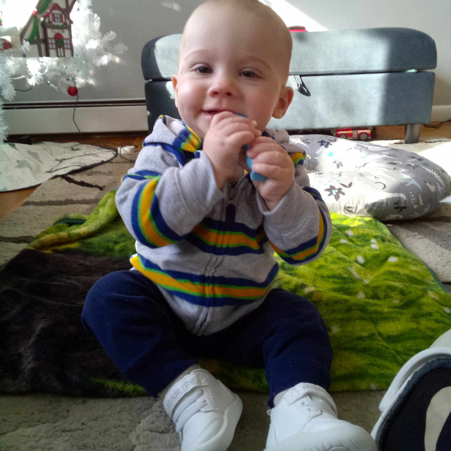 Bo is registered to the contest to win money with this photo: baby, bodypart, clothing, couch, cutlery, face, finger, footwear, furniture, hand, head, pants, person, photography, portrait, runningshoe, shoe, sitting, sneaker, spoon