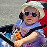 Mya a rejoint le concours — aidez-le/la à gagner de superbes lots ! toddler, child, sunglasses, hat, stroller, toy, bottle, sunhat, outdoor, baby, clothing, seatbelt, plastic_toy, pink, white_shirt, summer, cute, sunny, portrait, baby_toy