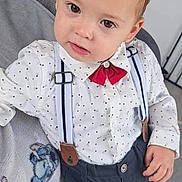 Maylone a rejoint le concours — aidez-le/la à gagner de superbes lots ! child, toddler, boy, polka_dot_shirt, red_bow_tie, suspenders, spiky_hair, indoor, couch, blanket, stairs, curious_expression, casual_pose, furniture, person, portrait, young_child, home, clothing, fashion