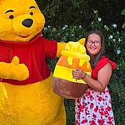 Alycia participe au concours pour gagner de l'argent avec cette photo : child, girl, costume, character, mascot, winnie_the_pooh, honey_pot, plush, smile, glasses, floral_dress, outdoor, greenery, flowers, nature, fun, happy, portrait, person, summer