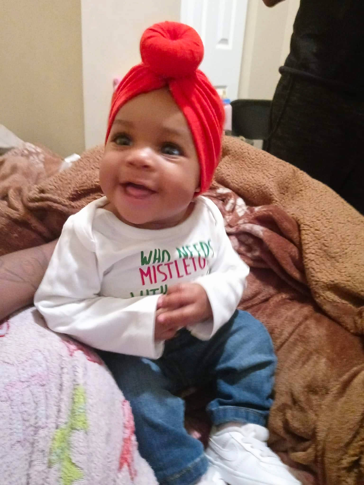 Maleah is registered to the contest to win money with this photo: baby, baby_toddler_clothing, cap, child, comfort, costume_hat, couch, event, eye, happy, hat, head, headgear, headwear, human_body, lap, outerwear, person, skin, sleeve