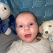 Mathys participe au concours pour gagner de l'argent avec cette photo : baby, infant, child, smiling, open_mouth, blue_blanket, stuffed_animal, plush_toy, onesie, portrait, face, eyes, indoor, bedroom, pacifier_clip, bedding, head, cute, flash_photography, toy_dog