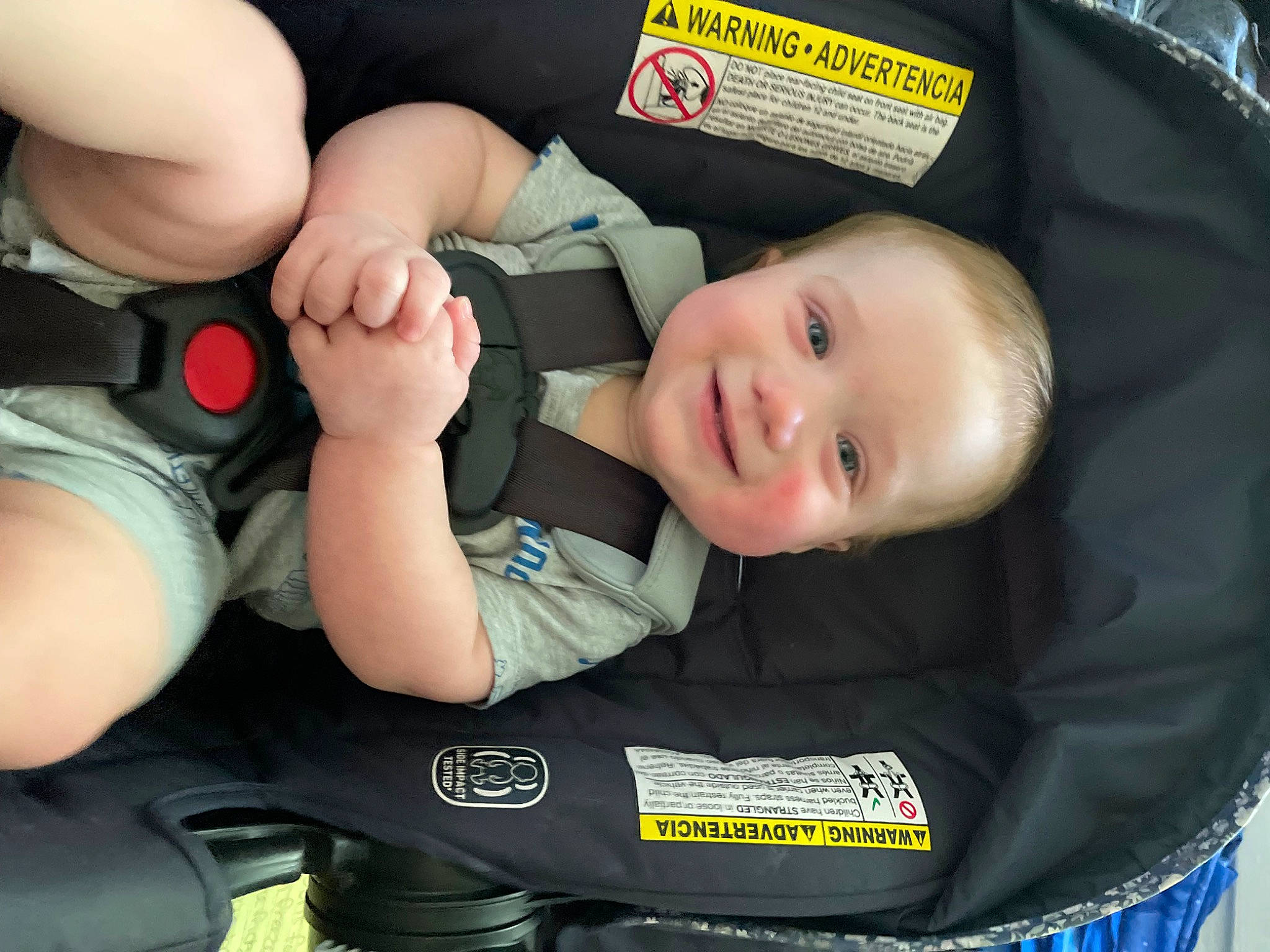 Killian is registered to the contest to win money with this photo: auto_part, baby, baby_carriage, baby_in_car_seat, baby_products, baby_toddler_clothing, black, car_seat, child, comfort, elbow, fun, gesture, human_body, joy, knee, person, product, smile, thumb