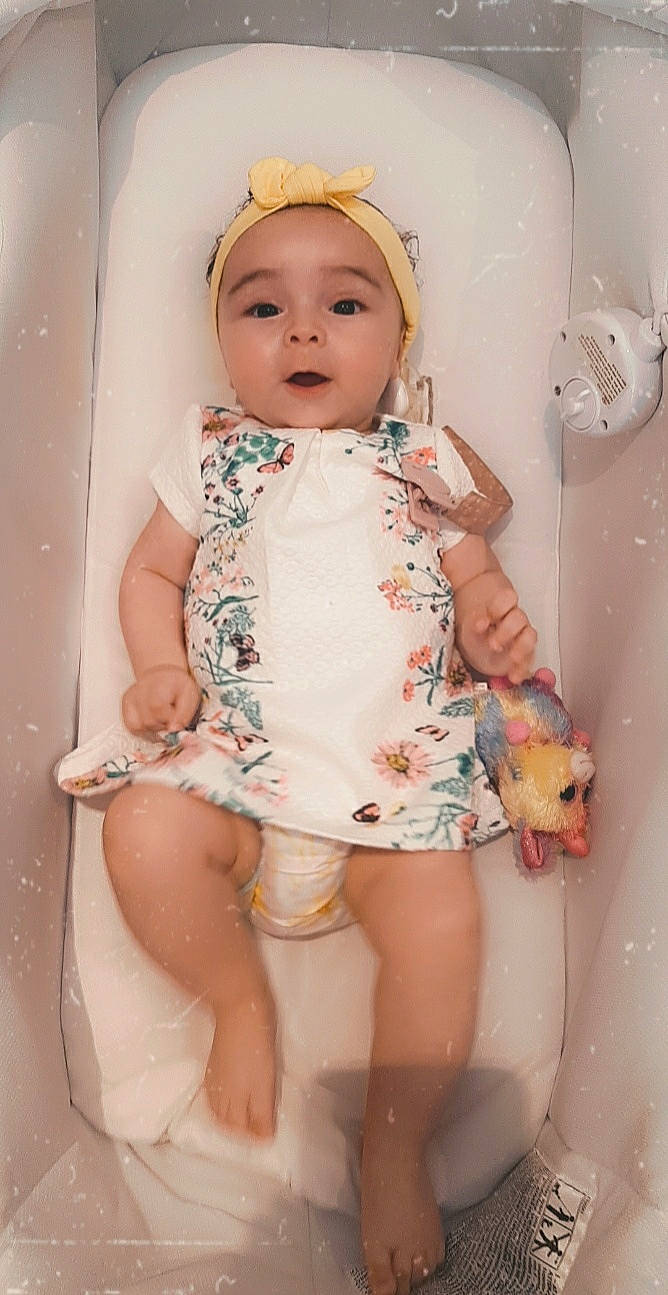 Amalia participe au concours pour gagner de l'argent avec cette photo : arm, baby, baby_toddler_clothing, cheek, eye, eyelash, finger, head, human_body, iris, lip, mouth, neck, organ, person, pink, skin, sleeve, stomach, thigh