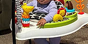 True joined the competition — help win amazing prizes! activity_jumper, animal_toy, baby, carpet, child, clothing, colorful, cute, expression, face, furniture, indoor, infant, person, plastic, playful, purple_outfit, scrunched_face, seat, toy