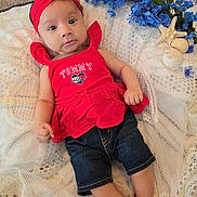 Amyra joined the competition — help win amazing prizes! baby, infant, red_clothing, headband, blue_flowers, seashells, lace_fabric, lying_down, curious_expression, indoors, cute, portrait, child, person, decor, soft_lighting, casual, denim_shorts, bracelet, closeup