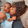 Raydon is registered to the contest to win money with this photo: baby, child, person, kiss, smile, love, affection, curly_hair, indoor, fan, clock, holding, happy, heart_stickers, casual_clothing, closeup, family, interaction, cute, joy