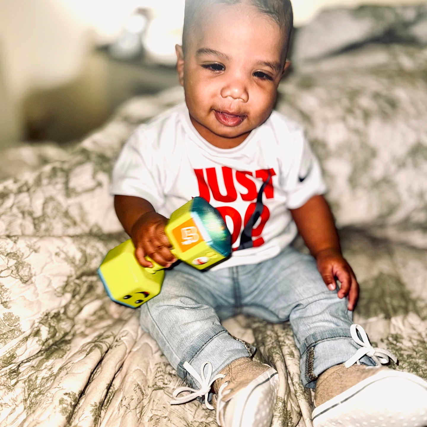 Raydon joined the competition — help win amazing prizes! baby, bed, blanket, child, clothing, cute, dumbbell, footwear, home, indoor, infant, jeans, person, portrait, shirt, sitting, smile, sneakers, toy, young