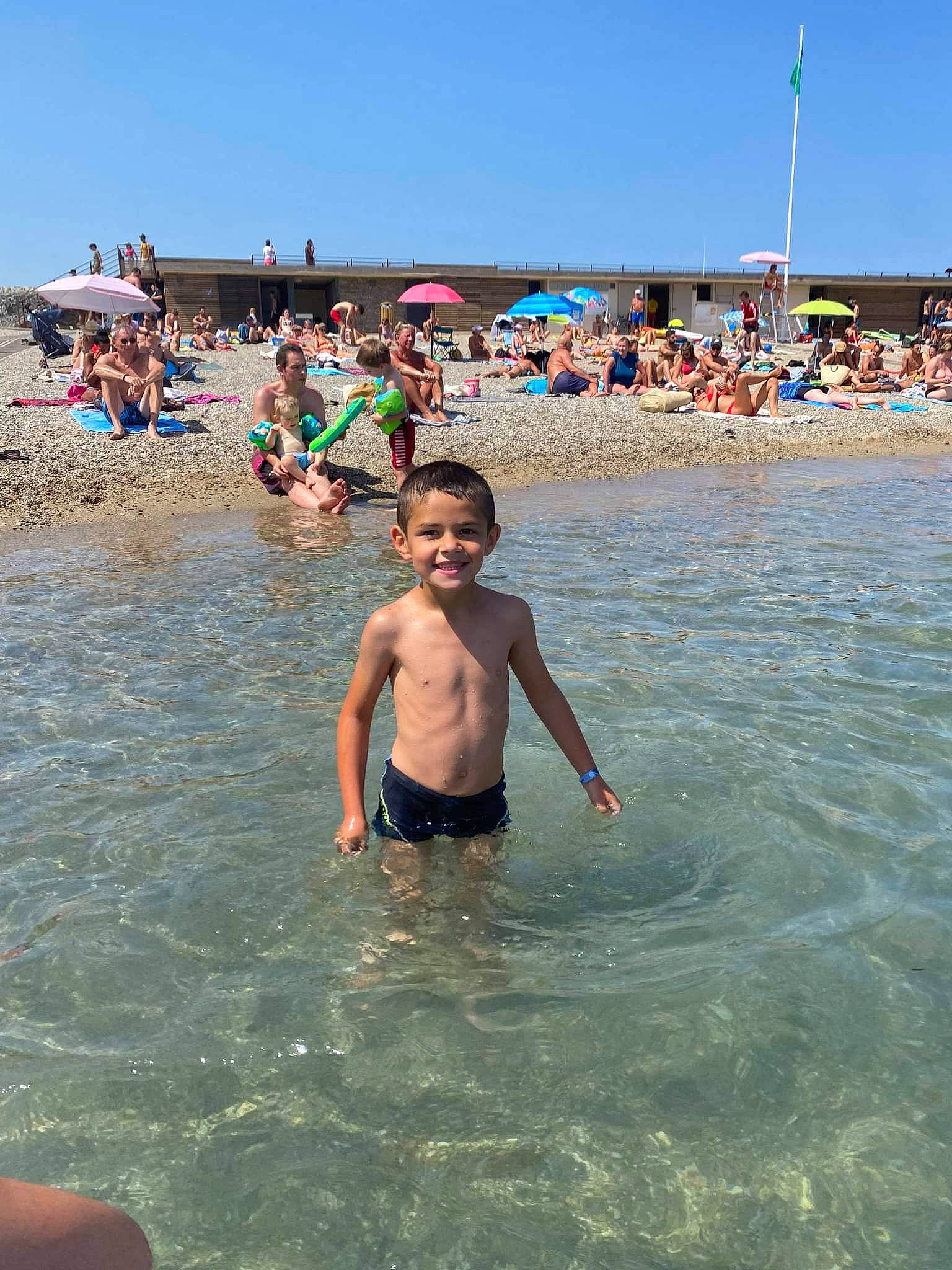 Malonn participe au concours pour gagner de l'argent avec cette photo : barechested, bathing, beach, body_of_water, coastal_and_oceanic_landforms, fun, happy, holiday, joy, lake, leisure, people_on_beach, person, sand, shore, sky, smile, swimwear, toddler, travel