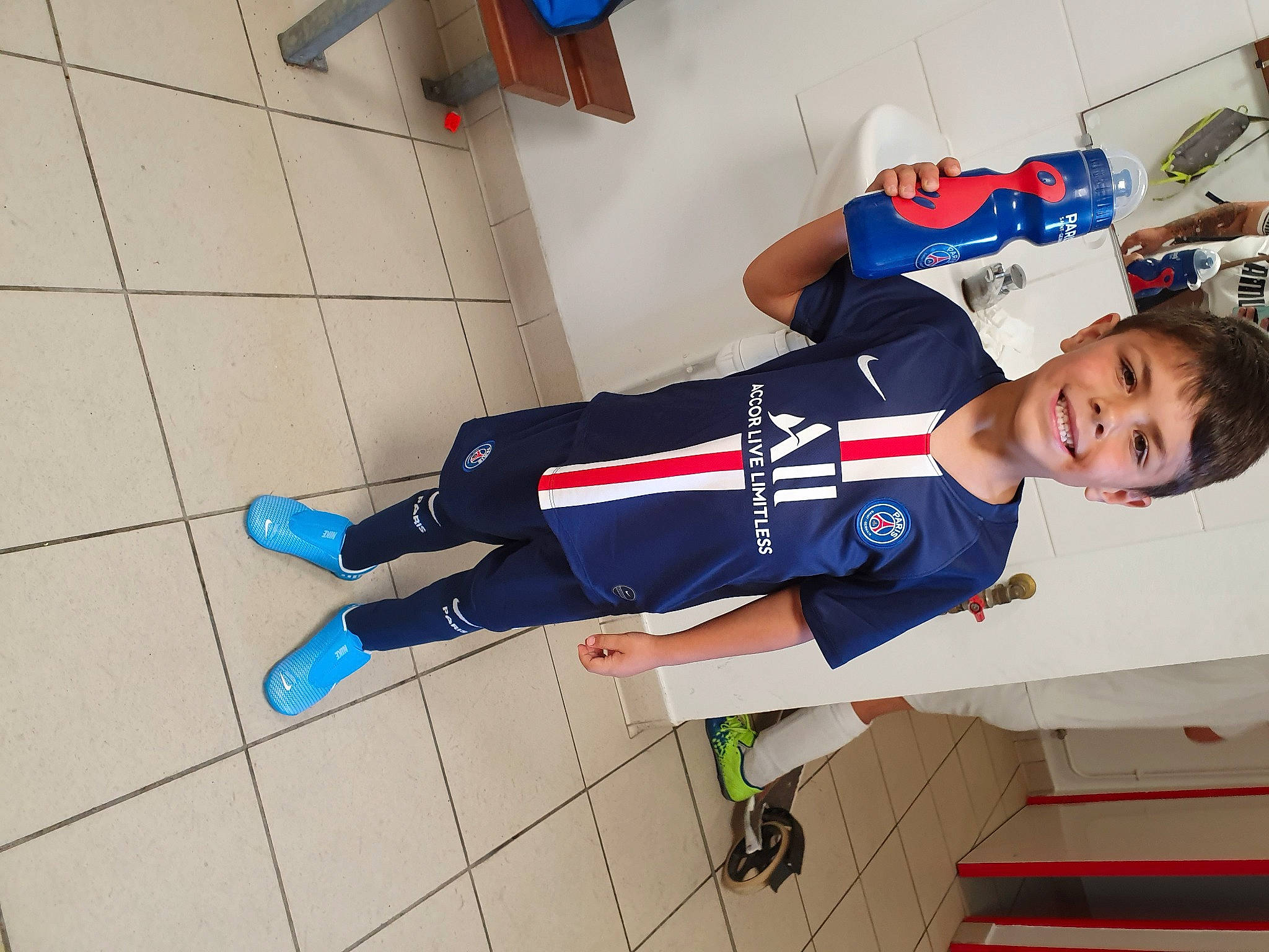 Kayron a rejoint le concours — aidez-le/la à gagner de superbes lots ! baby_toddler_clothing, carmine, child, cleanliness, elbow, electric_blue, flooring, fun, human_leg, joy, knee, person, room, sleeve, smile, sportswear, t_shirt, thigh, toddler, uniform