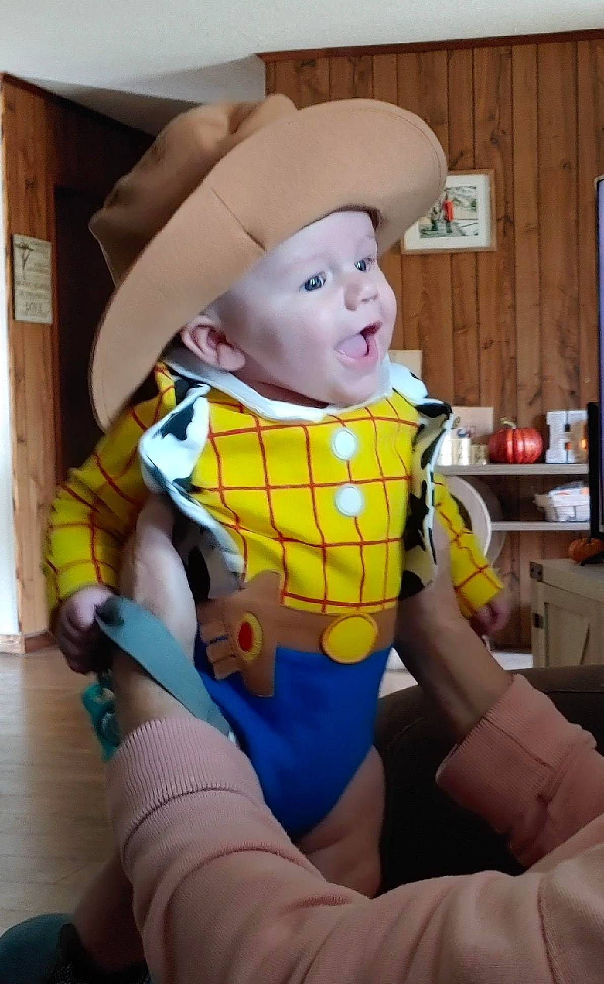 Carson is registered to the contest to win money with this photo: art, baby, baby_products, cabinetry, child, fictional_character, fun, hand, happy, headwear, human_leg, lap, pattern, person, personal_protective_equipment, room, sitting, sleeve, smile, thigh