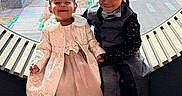 Amria is registered to the contest to win money with this photo: bow_tie, boy, cars, child, children, daylight, dressed_up, formal_clothing, girl, hair_bows, happy, ledges, outdoor_view, portrait, shoes, sidewalk, sitting, smiling, street, window