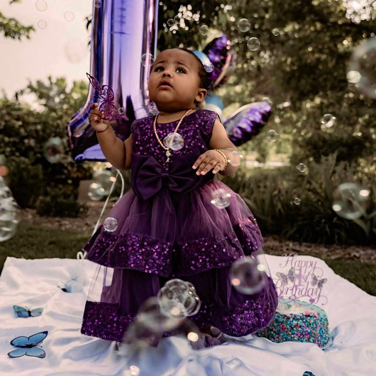 Amria joined the competition — help win amazing prizes! balloon, birthday, blanket, bracelet, bubbles, butterfly, cake, celebration, child, dress, grass, happy, necklace, number_one, outdoor, party, purple, sunlight, toddler, trees