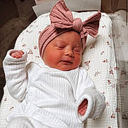Kennedy is registered to the contest to win money with this photo: newborn, baby, sleeping, headband, pink_bow, white_clothing, blanket, floral_pattern, infant, cute, peaceful, soft_texture, child, portrait, indoors, resting, cozy, small_hands, wrapped, toddler