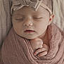 baby, sleeping, newborn, headband, bow, pink_blanket, wrapped, peaceful, infant, cute, portrait, closeup, hands, soft_texture, cozy, resting, child, adorable, indoors, face