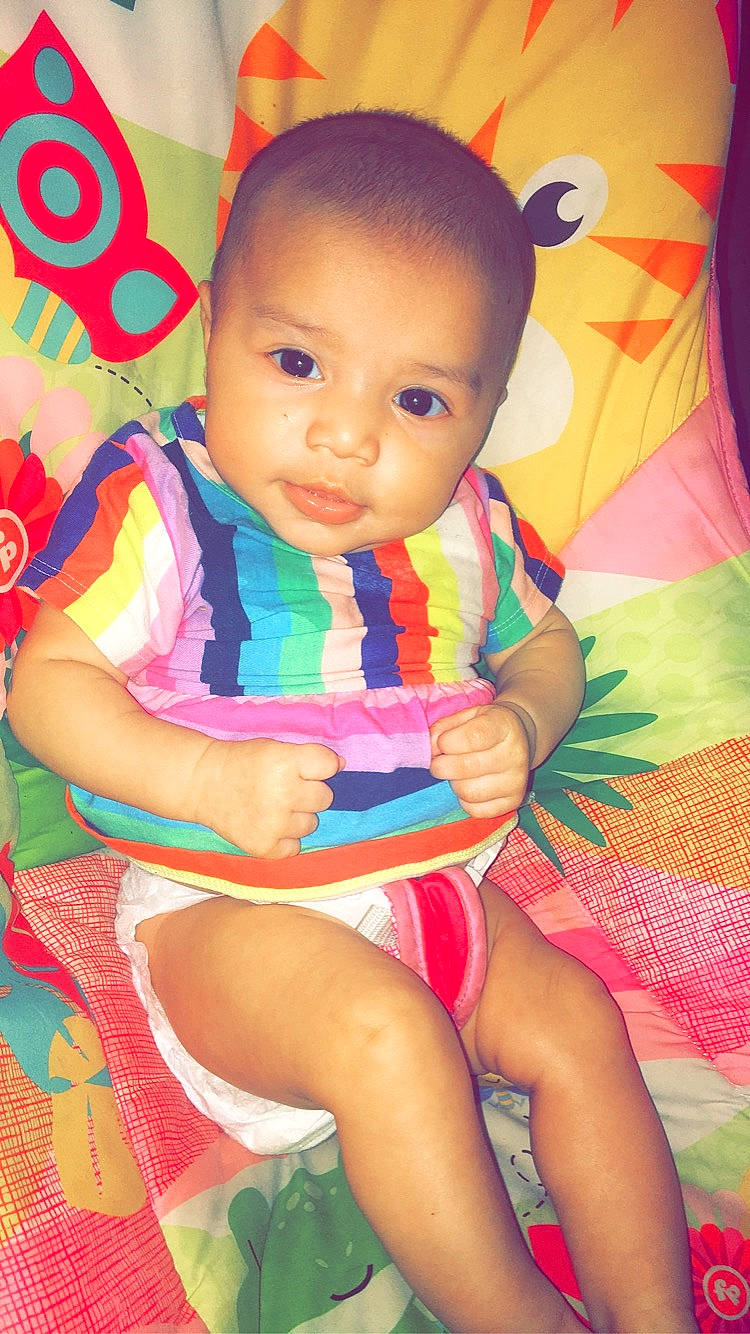 Londynn is registered to the contest to win money with this photo: baby, baby_toddler_clothing, cheek, child, face, fun, happy, human_leg, knee, lap, magenta, neck, pattern, person, pink, play, sitting, skin, sleeve, thigh