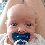 Oliver joined the competition — help win amazing prizes! baby, pacifier, blue, face, eyes, infant, closeup, person, legs, white_clothing, indoors, expression, portrait, child, human, skin, head, cute, small, newborn