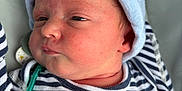 Oliver joined the competition — help win amazing prizes! baby, newborn, infant, striped_clothing, hat, face, skin, pacifier, blanket, close_up, portrait, cute, sleepy, child, young, person, soft, cozy, indoors, resting