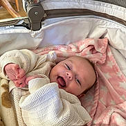 Ophelia is registered to the contest to win money with this photo: baby, blanket, child, clothing, cozy, cream, cute, face, happy, indoors, infant, lying, newborn, pattern, pink, portrait, smile, soft, stroller, warm