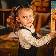 Louna a rejoint le concours — aidez-le/la à gagner de superbes lots ! art, brushes, canvas, child, clothing, cozy, creative, expression, face, girl, hair, indoor, long_sleeve, overalls, paintbrush, painting, pigtails, smiling, table, warm_lighting