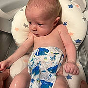 Braxton joined the competition — help win amazing prizes! baby, infant, towel, bath, water, cushion, star_pattern, blue_whales, skin, hand, face, head, newborn, bath_support, child, wet, expression, indoors, person, cute