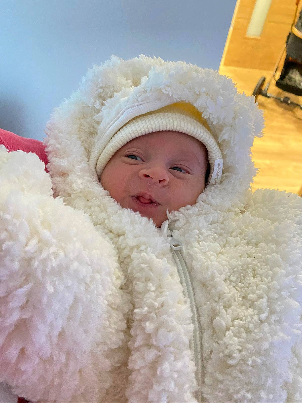 Carla a rejoint le concours — aidez-le/la à gagner de superbes lots ! baby, baby_toddler_clothing, beanie, cap, child, comfort, eye, fur, fur_clothing, happy, hat, headwear, hoodie, jacket, parka, peach, person, pink, skin, toddler