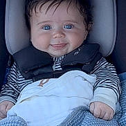 Tyler is registered to the contest to win money with this photo: baby, blue_eyes, car_seat, blanket, smile, child, infant, striped_clothing, cute, happy, indoors, person, portrait, sitting, young_child, cozy, hands, face, head_support, clothing