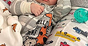 Tyler is registered to the contest to win money with this photo: baby, sleeping, pajamas, striped_clothing, pacifier, pillow, vehicles, blanket, bed, cute, child, infant, rest, cozy, soft_lighting, indoor, peaceful, comfort, face, hand