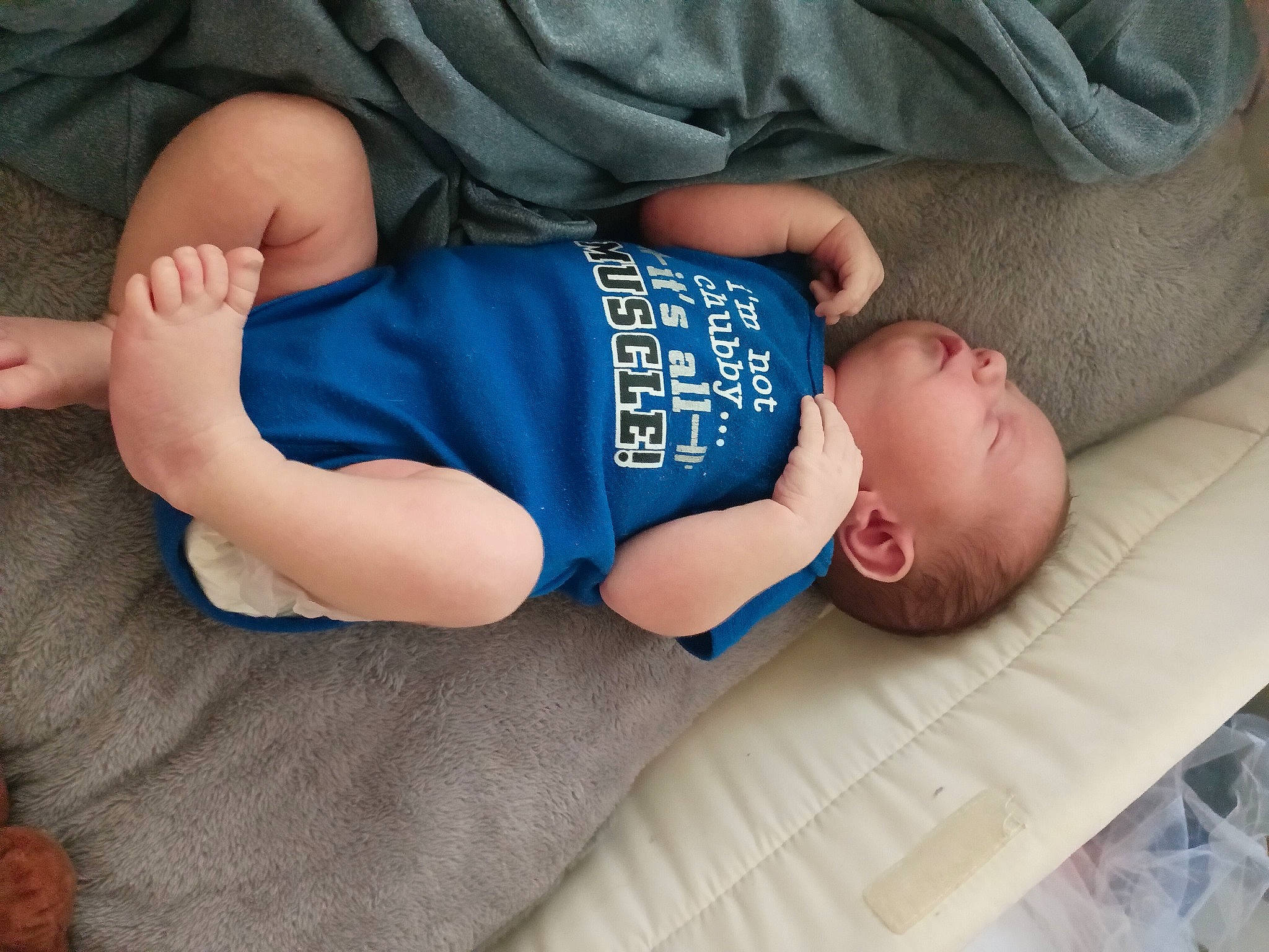 Ryker is registered to the contest to win money with this photo: baby, baby_sleeping, baby_toddler_clothing, comfort, elbow, face, finger, foot, hand, head, human_body, human_leg, knee, pattern, person, skin, sleeve, sock, thigh, thumb