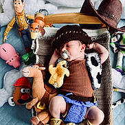 Remco a rejoint le concours — aidez-le/la à gagner de superbes lots ! baby, sleeping, cowboy_hat, toy_story, woody, buzz_lightyear, mr_potato_head, plush_toy, stuffed_animal, wooden_bed, blanket, pacifier, crochet_clothing, horse_plush, bedroom, child, cute, costume, soft_toys, resting