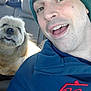 beanie, car_interior, casual_clothing, closeup, companionship, dog, facial_expression, friendship, furry_dog, happy, headwear, human, indoors, light_fur, man, pet, portrait, seated, smiling, vehicle