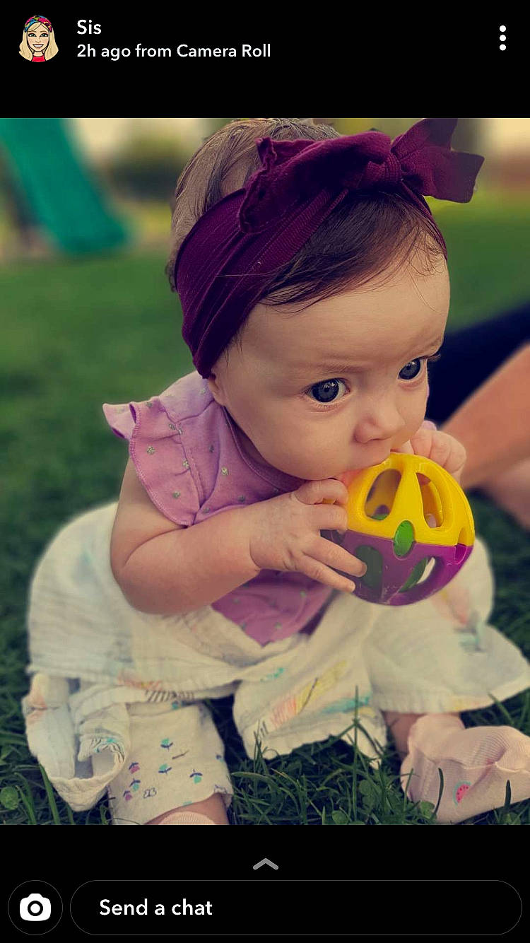 Genesis is registered to the contest to win money with this photo: baby, ball, brown_hair, cheek, child, eye, hair_accessory, head, headband, headgear, iris, mouth, nose, person, photography, pink, plant, play, purple, skin