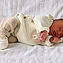 newborn, baby, sleeping, knitted_clothing, white_blanket, infant, cozy, cute, peaceful, portrait, soft_texture, small_hands, tiny_feet, warm, resting, child, indoors, closeup, comfort, adorable
