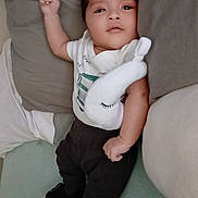 Giovanni joined the competition — help win amazing prizes! baby, bed, black_pants, casual_clothing, child, comfortable, cute, indoor, infant, looking_at_camera, lying_down, pillow, plush_toy, relaxed, resting, small_shoes, sneakers, soft_toy, white_shirt, young_child