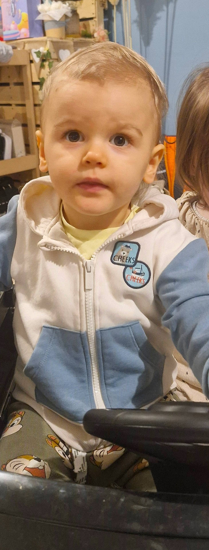 baby, child, clothing, coat, computer, electronics, face, female, furniture, girl, head, jacket, knitwear, pants, person, photography, portrait, sitting, sweater, t_shirt