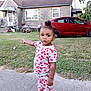 toddler, child, pajamas, slippers, sidewalk, grass, house, car, pointing, outdoor, daylight, curly_hair, expression, clothing, footwear, person, yard, residential, suburban, casual