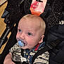 baby, pacifier, bat_headband, stroller, striped_shirt, blue_eyes, denim_collar, black_headband, sparkly, infant, child, cute, baby_clothing, face, hand, seatbelt, indoors, shopping, retail, curious