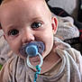 baby, child, pacifier, blue_pacifier, close_up, face, eyes, shirt, bear_design, toddler, indoors, soft_light, curious, cute, infant, clothing, person, portrait, young_child, expression