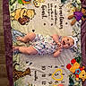 baby, child, smiling, lying_down, blanket, winnie_the_pooh, toy, headband, romper, floor, wood_floor, colorful, milestone_blanket, infant, happy, playful, clothing, portrait, indoors, cute