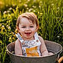 Rory joined the competition — help win amazing prizes! toddler, child, bucket, grass, flowers, outdoor, smiling, happy, blue_eyes, overalls, sunlight, nature, cute, portrait, baby, summer, greenery, playful, sitting, innocence