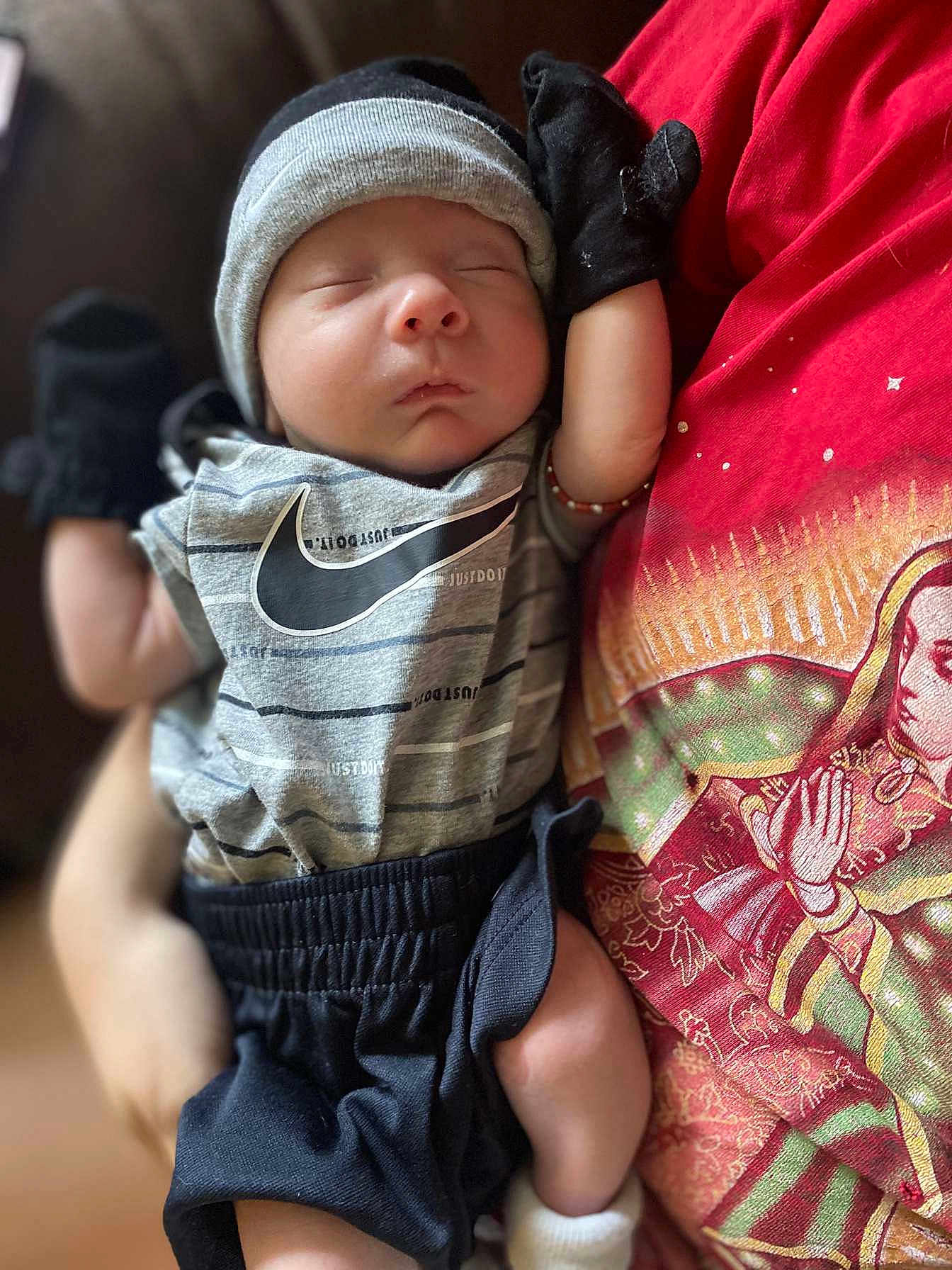 Juan joined the competition — help win amazing prizes! baby, newborn, sleeping, infant, clothing, mittens, hat, person, holding, tshirt, fabric, pattern, closeup, soft_focus, indoor, cute, peaceful, resting, portrait, hand